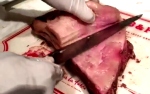 Removing the fat from the cooked ribs.
